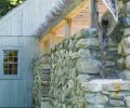 A stone wall constructed from local granite connects the two outbuildings, and is used as an entrance for guests arriving for a party.