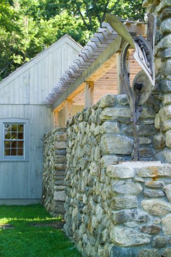 A stone wall constructed from local granite connects the two outbuildings, and is used as an entrance for guests arriving for a party.