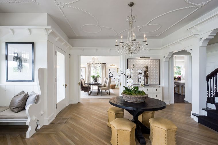 A large, gracious entryway
built for welcoming guests is one of the home’s most noteworthy features, but it also posed a design challenge. “I felt it was too naked to have nothing there,
too empty,” says Hester, so she placed a vintage black table in the center to add interest to the entryway. A crystal chandelier echoes the original plaster detail in the molding.