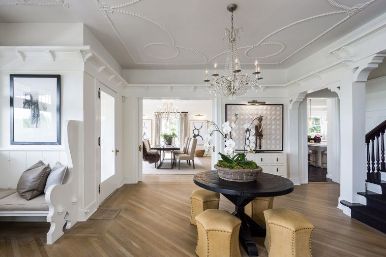 A large, gracious entryway
built for welcoming guests is one of the home’s most noteworthy features, but it also posed a design challenge. “I felt it was too naked to have nothing there,
too empty,” says Hester, so she placed a vintage black table in the center to add interest to the entryway. A crystal chandelier echoes the original plaster detail in the molding.