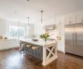 An extra-large island and refrigerator, expansive layout, abundant custom cabinetry, and clean, fresh lines make this kitchen perfect for a large, busy family. A four inch engineered plank floor anchors the space with rich color and texture, while
all-white cabinetry and transparent glass pendant lights keep the room feeling light and spacious.